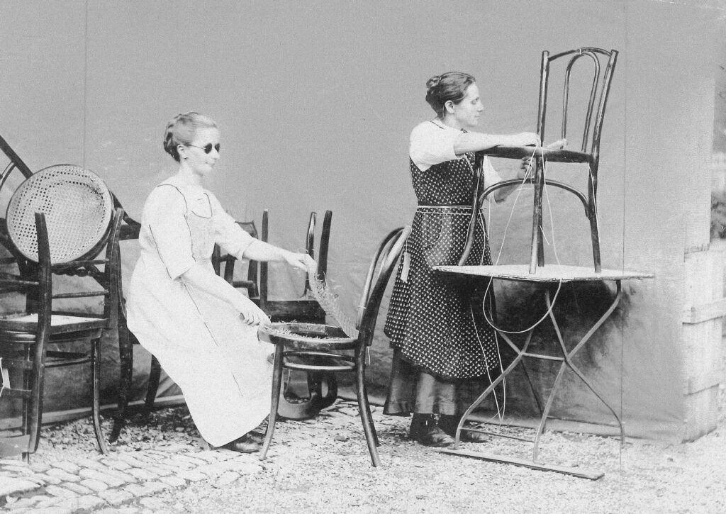 Schwarz/Weiss Aufnahme von zwei Frauen die in der Sesselflechterei im Jahr 1930 arbeiten. 