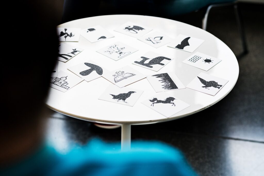 Weisser Tisch mit unterschiedlichen Karten mit diversen Symbolen.