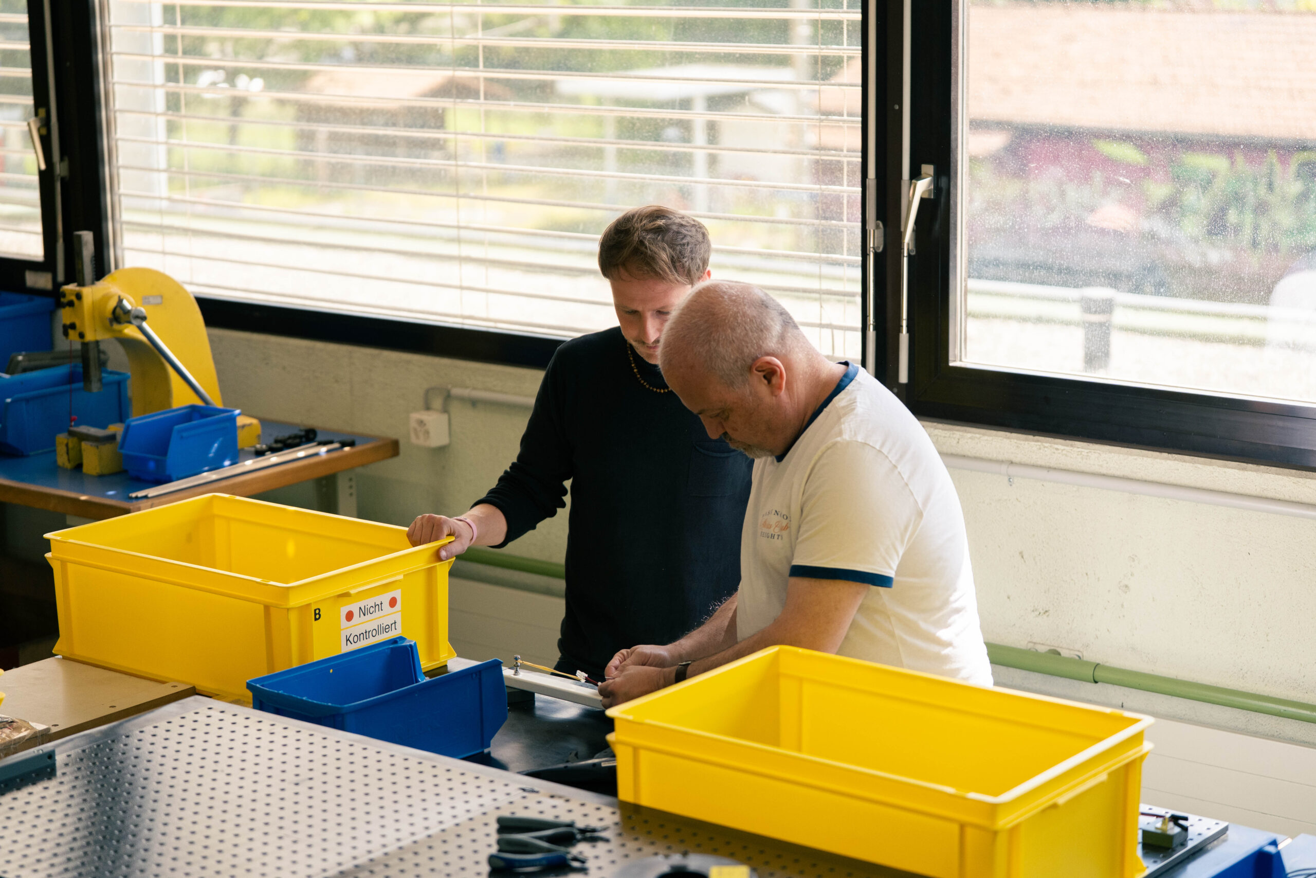 Zwei Mitarbeitende besprechen einen Auftrag in der industriellen Montage.