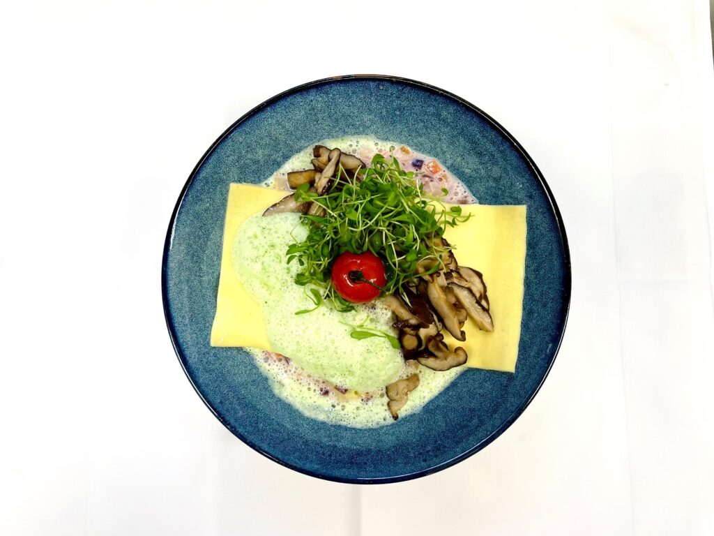 Offener Raviolo mit Shiitake Pilzen, dazu Wintergemüse und Kresseschaum.