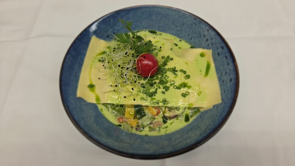 Offenes Raviolo mit Sommergemüse,
Shiitakepilzen und Liebstöckelsauce
